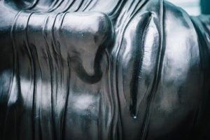 close up modern metal sculpture of a human face at Canary Wharf